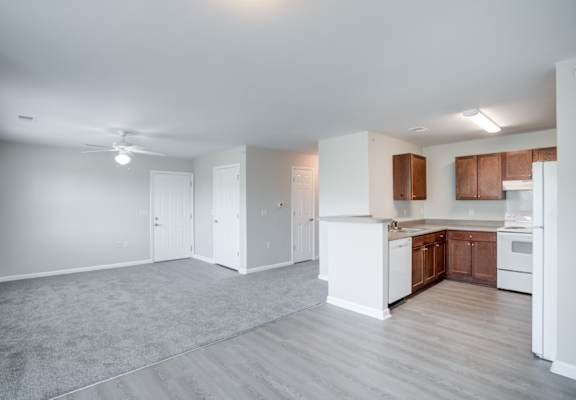 A spacious kitchen with white appliances and wooden cabinets.