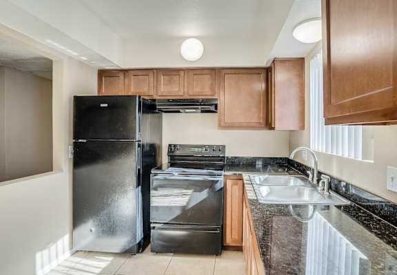 A kitchen with a black fridge, black oven and black dishwasher.