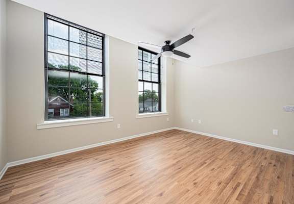 A room with wooden floors and a ceiling fan.