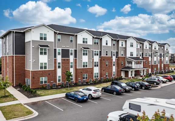 a large apartment building with a parking lot in front of it