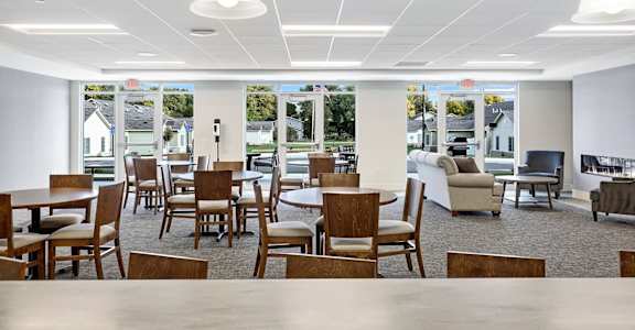 the lobby of a building with tables and chairs