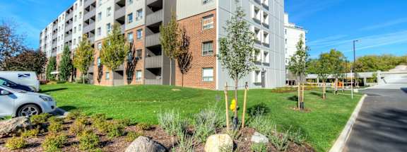 a large apartment building with many balconies and a grassy area in front of it at Platts Crossing, London, ON