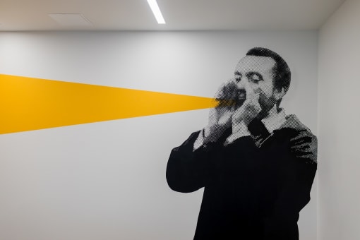 a mural of a man smoking a      on a white wall
