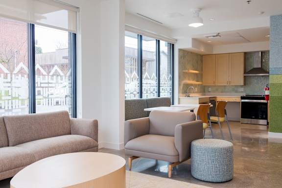 a living room with couches and chairs and a kitchen