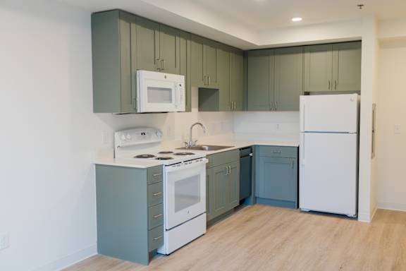 a kitchen with white appliances and blue and white cabinets