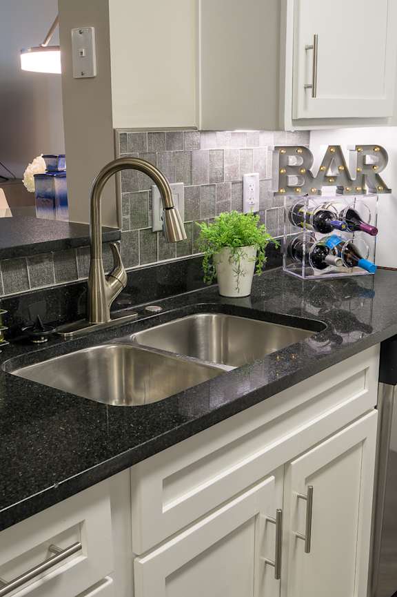 A modern kitchen with a stainless steel refrigerator, oven, and microwave.