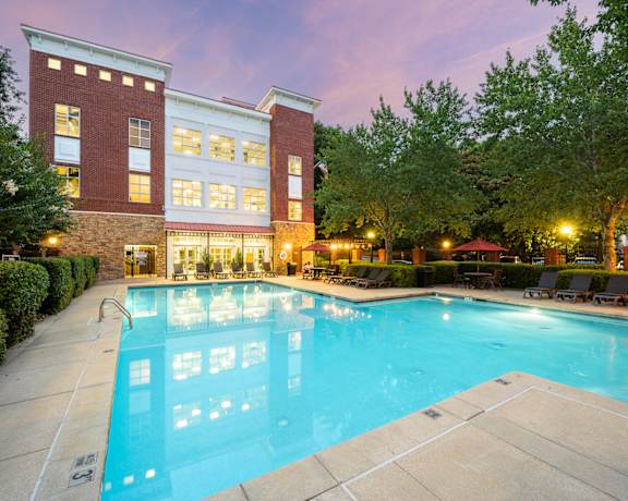 A large swimming pool in front of a red brick building.