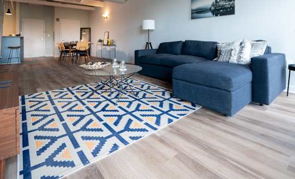 a living room with a blue couch and a rug