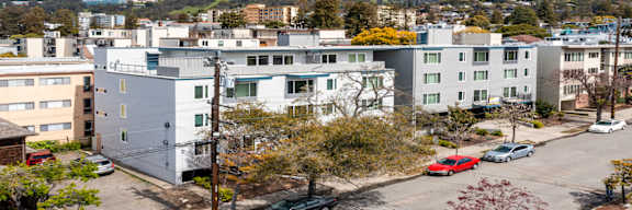 an aerial view of an apartment building with cars parked in front of it