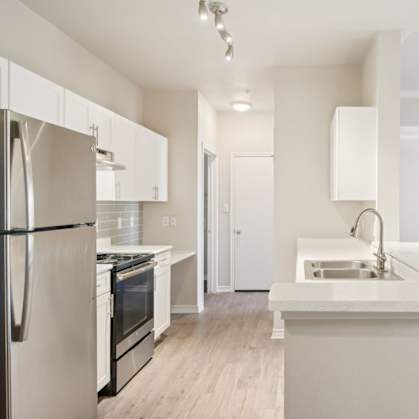 A modern kitchen with white appliances and cabinets.