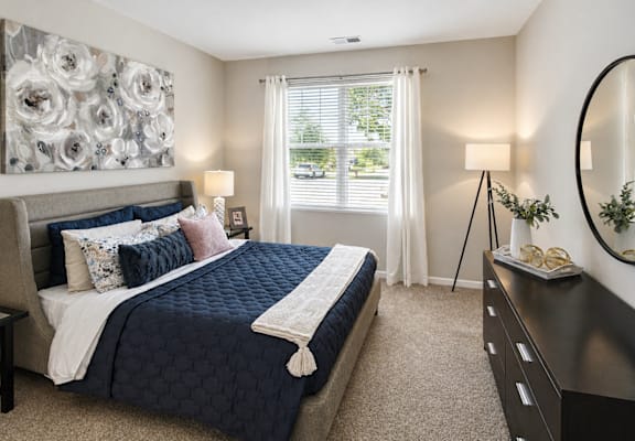 A bedroom with a large bed and a large floral painting on the wall.