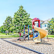 A playground with a blue slide and wooden structure.