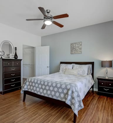 A bedroom with a bed, dresser, and mirror.