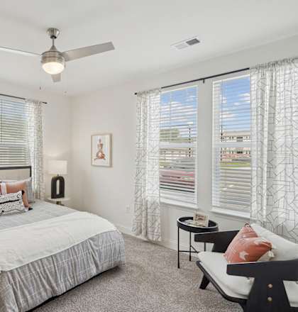 a bedroom with a bed and a ceiling fan
