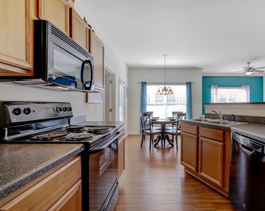A kitchen with wooden cabinets and a black stove top oven.