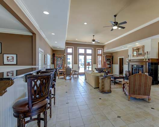 A large, well-lit living room with a fireplace and a bar area.