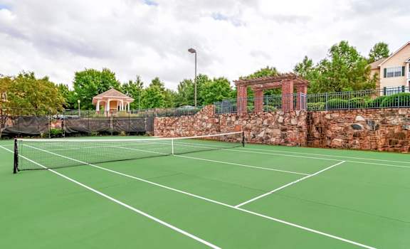 Outdoor tennis court with scenic landscaping and community amenities at Village at Almand Creek apartments in Conyers, GA. Perfect for recreation and active living.