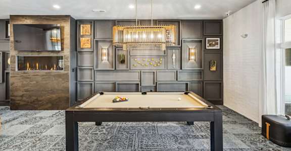 a game room with a pool table and a chandelier