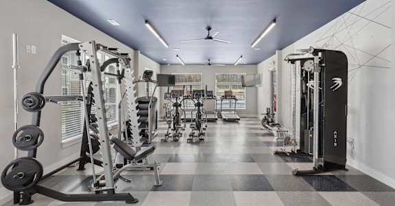 a gym with weights and cardio equipment on a checkered floor
