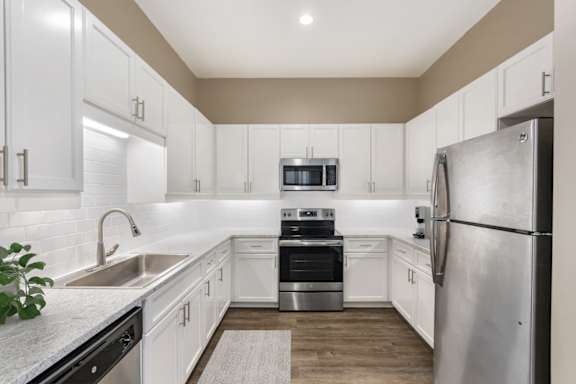 Modern kitchen with white cabinets and stainless steel appliances