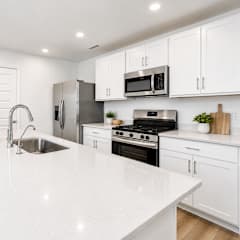 A modern kitchen with white cabinets and appliances.
