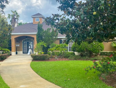 Club House Entrance with long sidewalk surrounded by trees