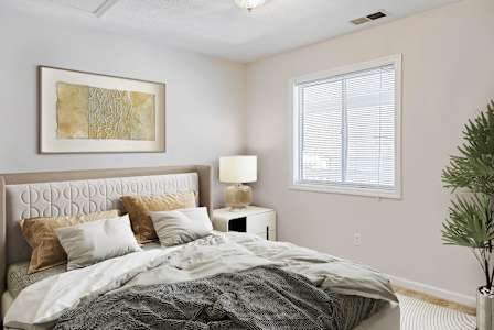 A living room with a wooden table and white couches.at Patriot Point Apartment Homes, Spring Lake, NC 28390