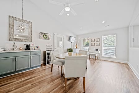 A living room with a wooden table and white couches.
