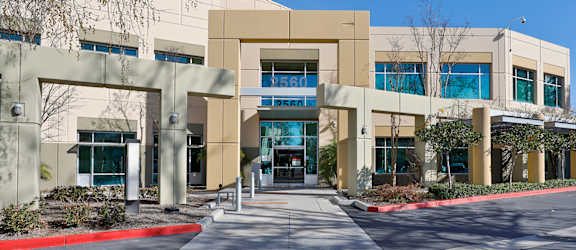 an office building with an entrance and a sidewalk in front of it
