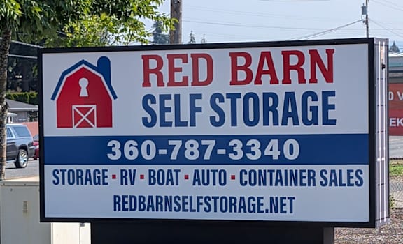 A sign for Red Barn Self Storage with a phone number and website listed.