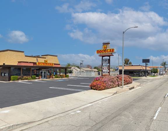 A road with a Burger King restaurant on the corner.