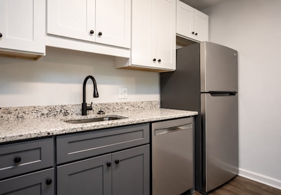 A kitchen with a sink and a refrigerator.