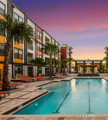 Resort-style swimming pool with large sundeck and lounge chairs at EOS Orlando
