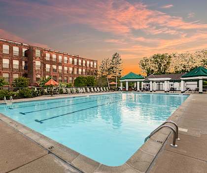 a swimming pool with a brick building in the background at Bigelow Commons, Enfield, 06082