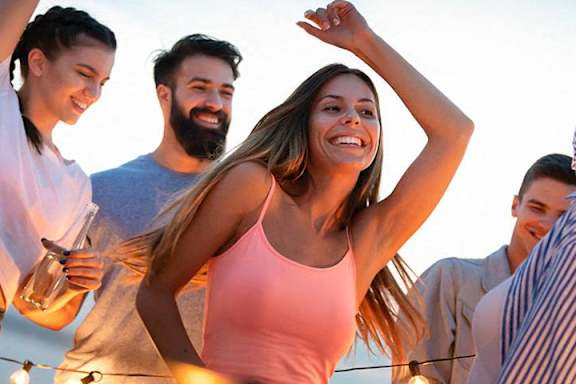 A group of friends are dancing together on a rooftop.