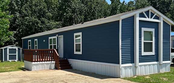 A blue house with a porch and a white door.