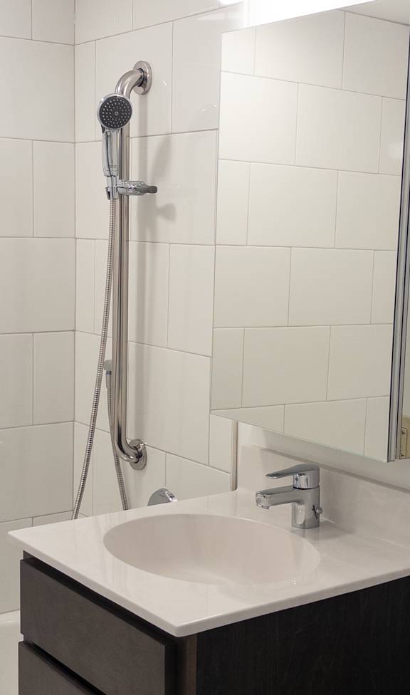 A white sink is on a countertop in a bathroom.