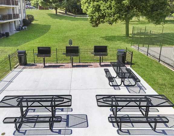 A black metal table and chairs are set up on a concrete patio.