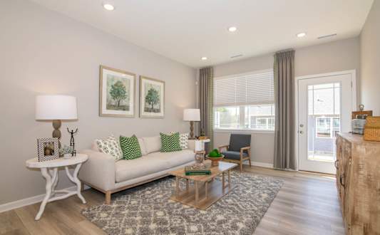 A living room with a white couch, a coffee table, and two framed pictures on the wall.