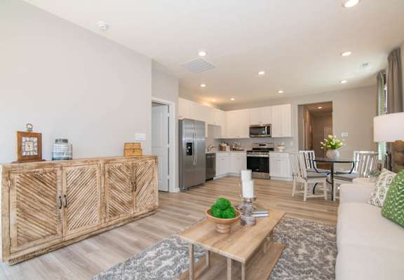 A modern kitchen with a wooden cabinet and a dining area with chairs.