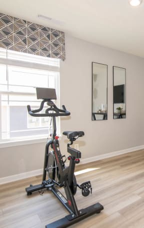a home gym with a exercise bike in front of a window at Jackson Run Townhomes, Indiana, 46075