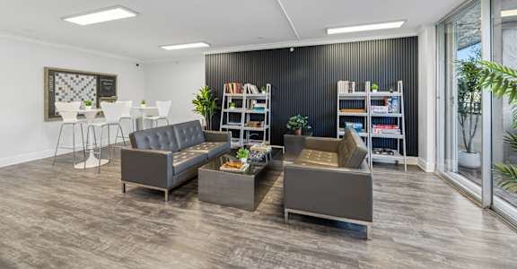 Resident lounge with modern seating and entertainment space at Wilton Tower in Wilton Manors, Florida.