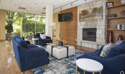 a living room with blue furniture and a stone fireplace