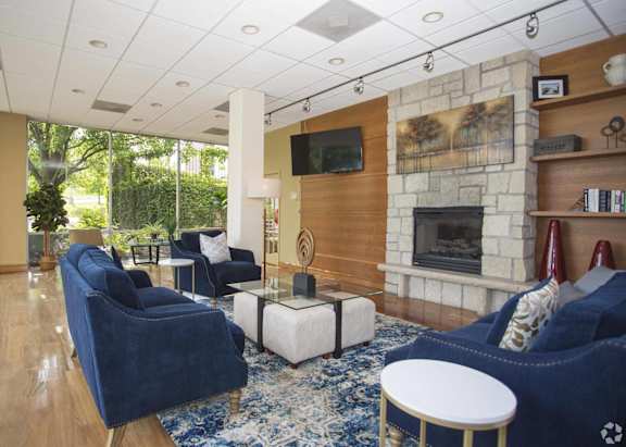 a living room with blue furniture and a stone fireplace