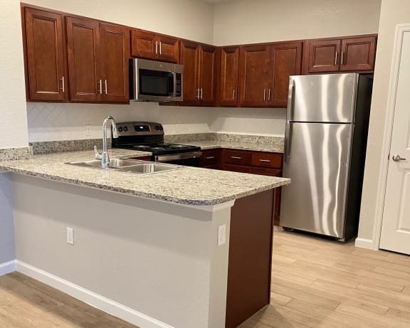 a kitchen with granite countertops and stainless steel appliances