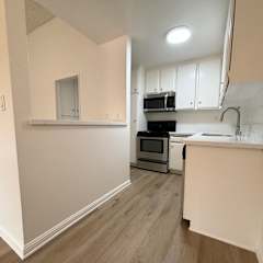 a view of a kitchen and a ceiling fan