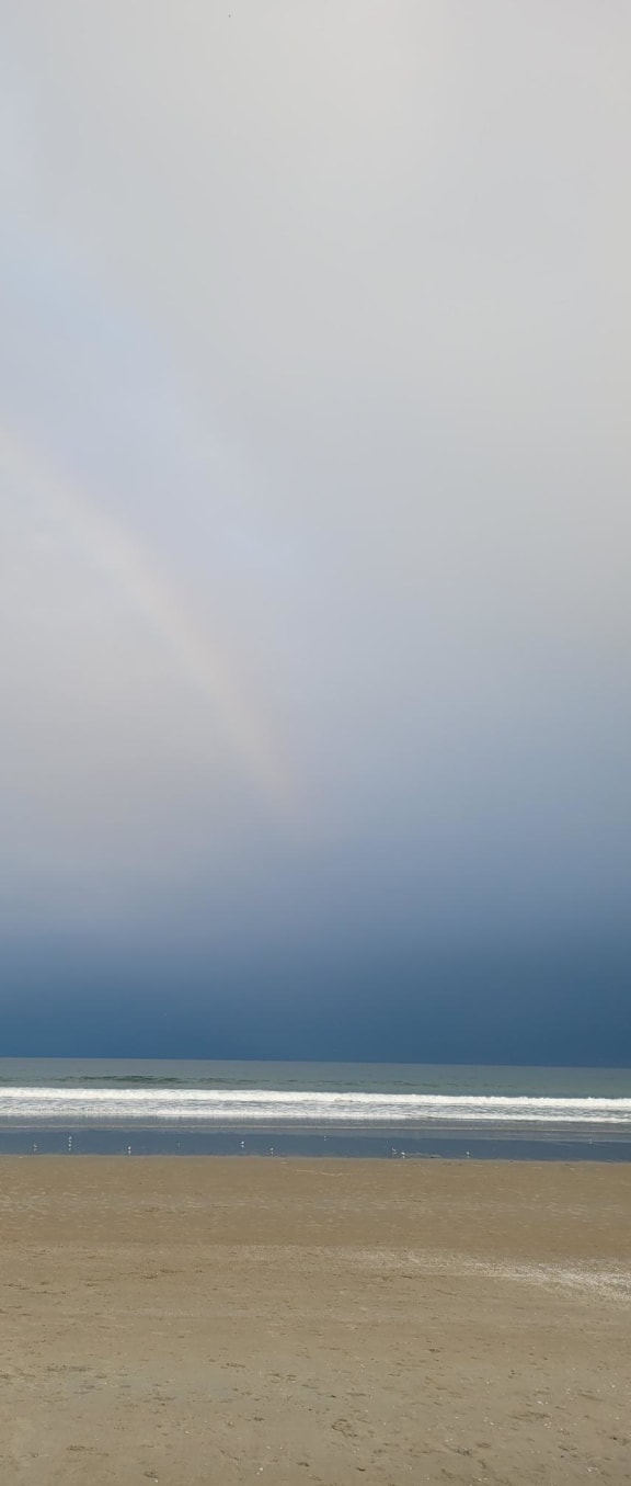 a rainbow in the sky over a body of water