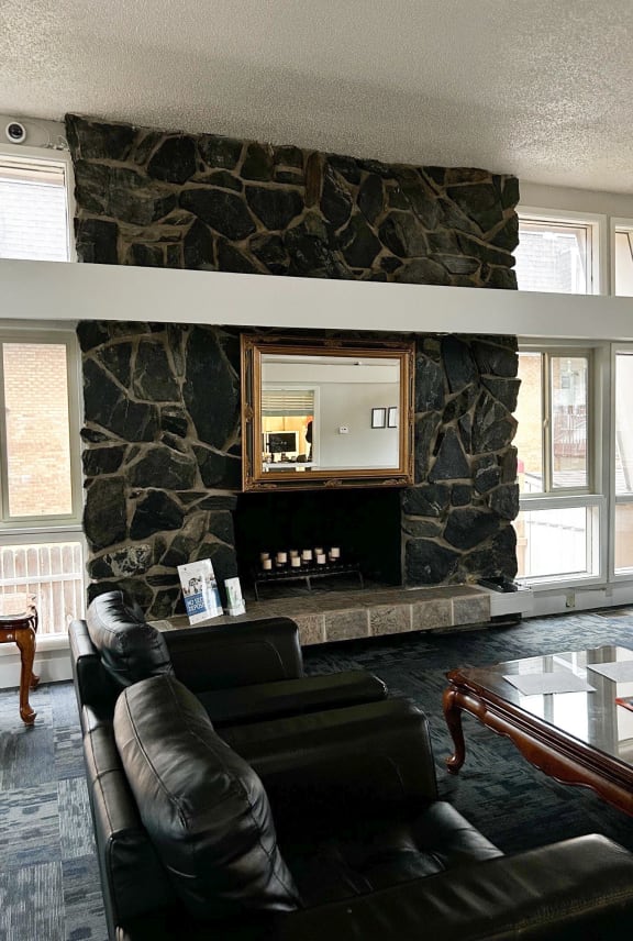a living room with leather furniture and a stone fireplace