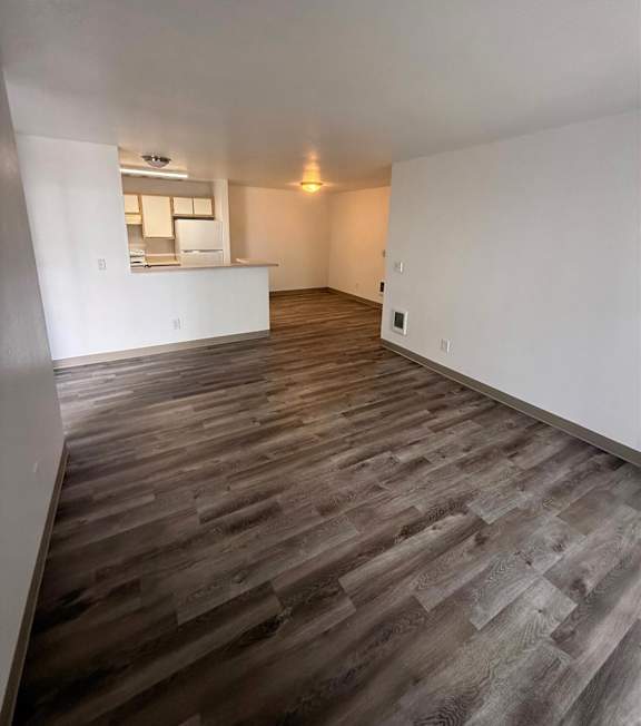 A room with wooden flooring and white walls.