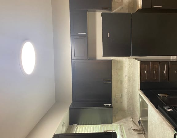 a kitchen with black cabinets and a black stove and a window at Hidden Woods, Decatur, GA